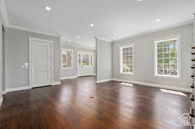 Unfurnished living room with crown molding, healthy amount of natural light, dark wood-style floors, and recessed lighting