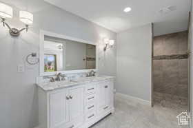 Full bathroom featuring double vanity, walk in shower, and recessed lighting