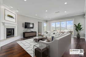 Living area with a premium fireplace, recessed lighting, dark wood-type flooring, and ornamental molding