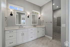 Bathroom with double vanity, a walk in shower, and recessed lighting