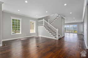 Unfurnished living room featuring stairs, dark wood-type flooring, and recessed lighting