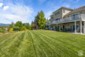 View of grassy yard with a deck