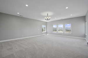 Upstairs level, largest of the 3 in total ensuite primary bedrooms light colored carpet, suspended lighting, mountain views