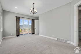 Unfurnished bedroom with carpet flooring, a chandelier, and access to exterior