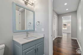 Bathroom featuring vanity, dark wood finished floors, and recessed lighting