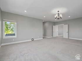 Spare room featuring light carpet, a chandelier, and recessed lighting
