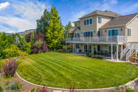 Back of house with a patio area, a lawn, a deck, and stairway
