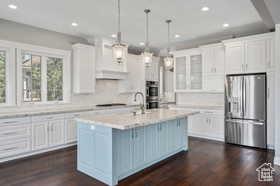 Kitchen featuring stainless steel appliances, recessed lighting, white cabinets, and pendant lighting