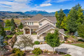 View of front of property featuring a mountain view and curved driveway