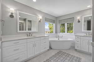 Top level ensuite bathroom featuring freestanding tub and two vanities