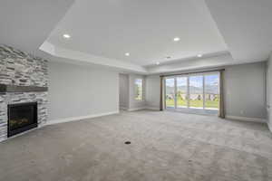 Lower level living area includes family room with mountain view, fireplace, light carpet, recessed lighting, tray ceiling, kitchen/pantry, walk-out ensuite primary bedroom, 2 more bedrooms, additional bathroom, HVAC room, storage room