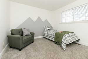 Bedroom featuring light carpet and baseboards