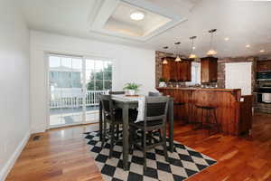 Dining area with healthy amount of natural light, dark wood-type flooring, and recessed lighting