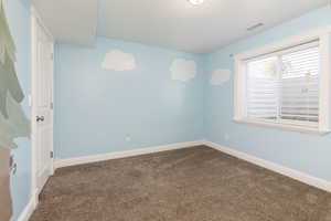 Carpeted empty room featuring baseboards