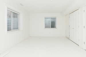 Unfurnished bedroom featuring a closet and multiple windows