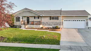 View of front of property with a shingled roof, driveway, a front lawn, and an attached garage