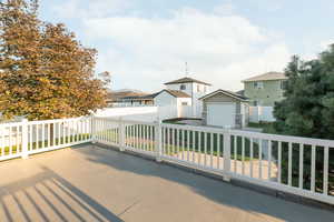View of patio / terrace featuring a residential view, an outbuilding, a garage, and driveway