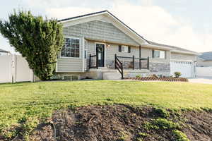 View of front of house featuring concrete driveway, stone siding, and a garage
