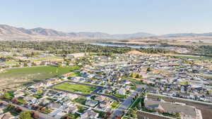 Aerial view of property and surrounding area featuring nearby suburban area and a water and mountain view