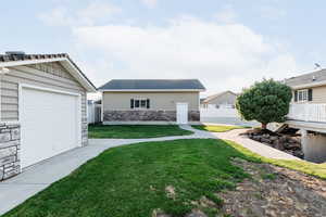 View of grassy yard with an outbuilding and a garage