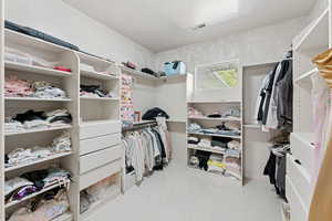 Primary bedroom walk in closet with custom shelves