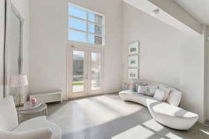 Entryway with finished concrete floors, french doors, and a high ceiling