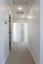 Corridor featuring carpet flooring and baseboards