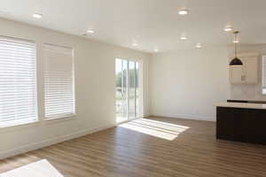 Unfurnished dining area featuring dark wood-type flooring and recessed lighting