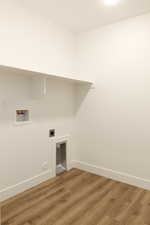 Laundry room with hookup for a washing machine, wood finished floors, and electric dryer hookup