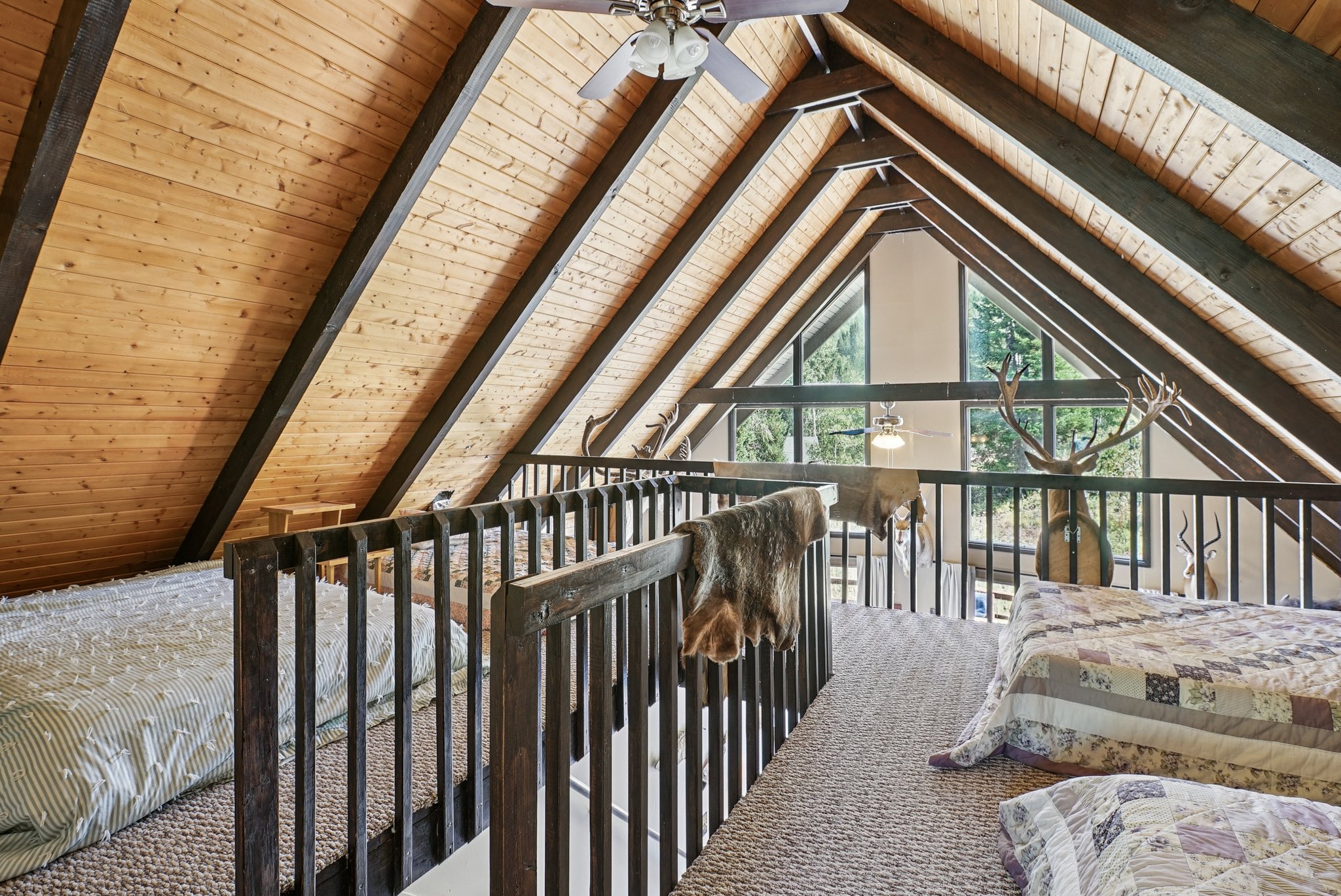Carpeted bedroom featuring wooden ceiling and a ceiling fan