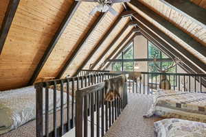 Carpeted bedroom featuring wooden ceiling and a ceiling fan