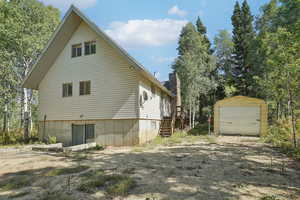 View of side of property with an outbuilding and stairway