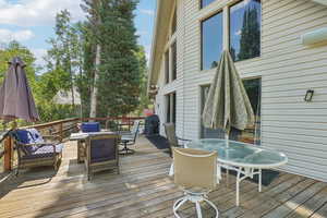 Wooden terrace with outdoor dining space and area for grilling