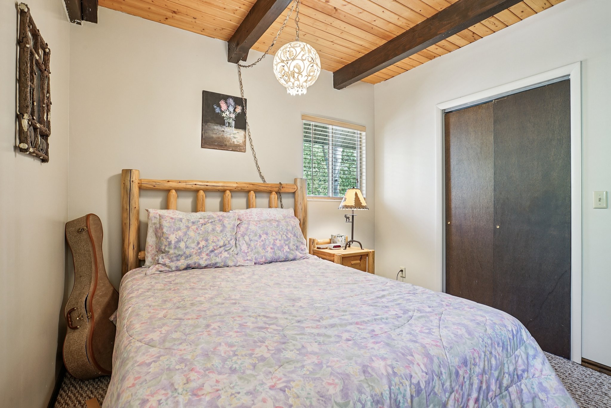 Bedroom featuring a wooden ceiling with exposed beams, a closet, a chandelier, and carpet