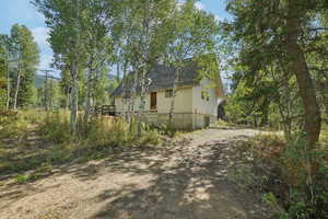 View of home's exterior featuring a shingled roof and driveway