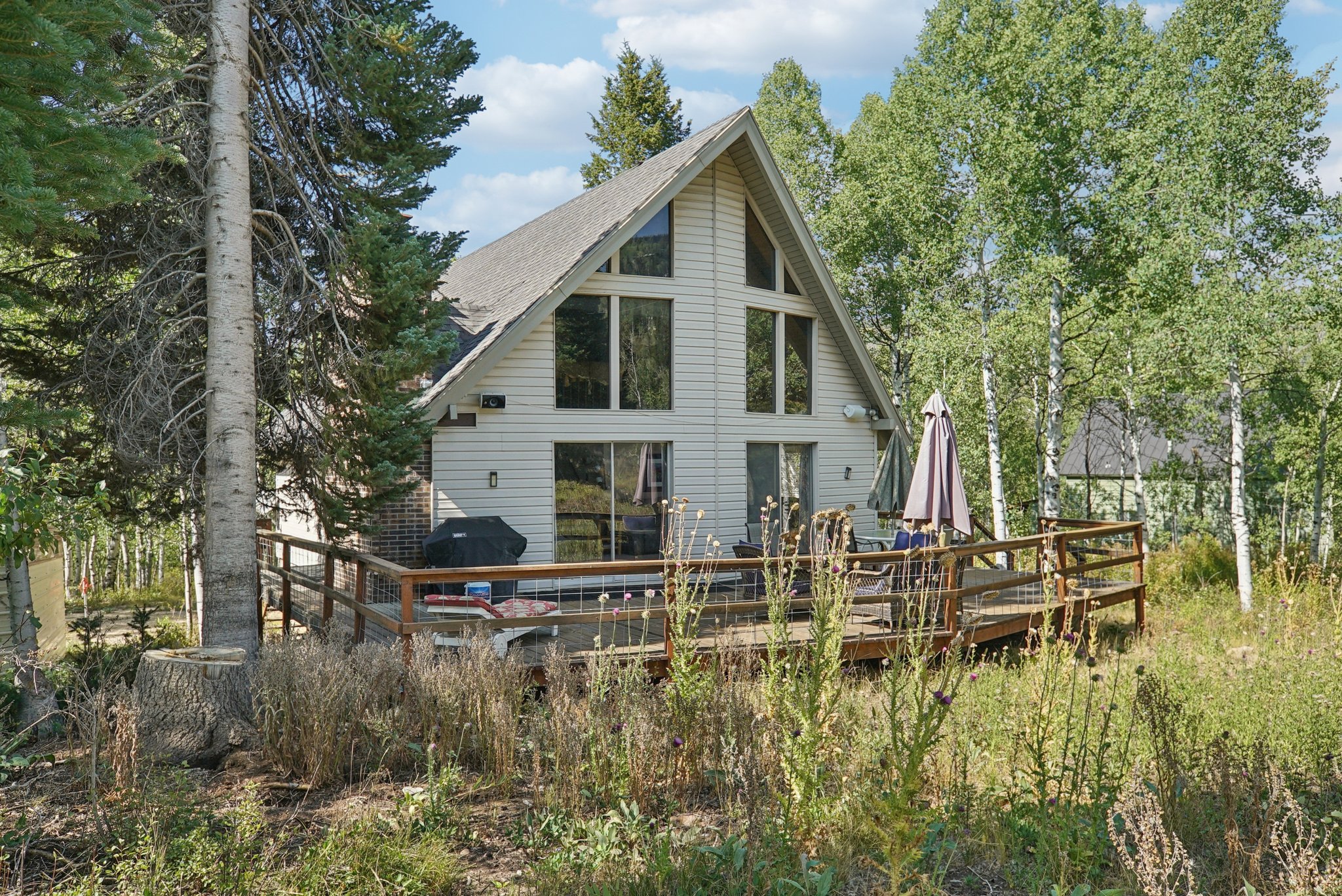 Back of property featuring a deck and a shingled roof