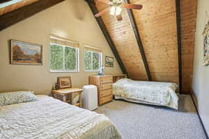 Bedroom featuring wood ceiling, carpet flooring, and a ceiling fan