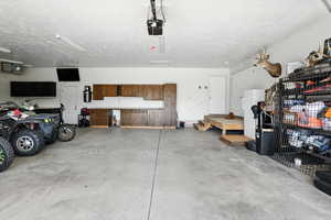 Garage featuring a heating unit and cabinetry workspace