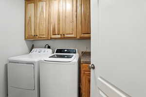 Laundry room featuring cabinet space and separate washer and dryer