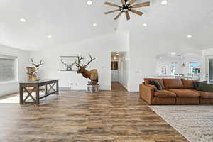 Living area with healthy amount of natural light, wood finished floors, arched walkways, recessed lighting, and ceiling fan