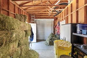 View of inside of barn with cemented floor and overhead door