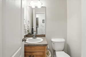 Half bathroom featuring vanity and toilet