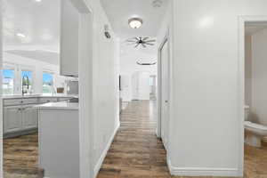 Hall featuring arched walkways, dark wood-style flooring