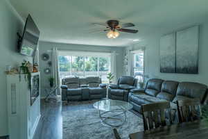 Living area with laminate finished floors, a ceiling fan