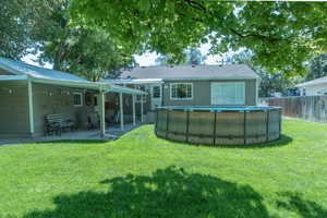 Back of property with a patio area and a lawn