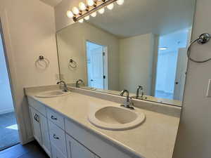 Bathroom featuring double vanity and dark tile patterned flooring