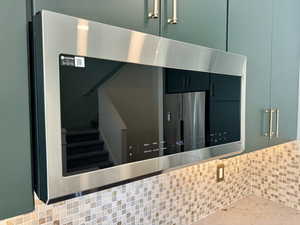 Kitchen view of stainless steel microwave and decorative backsplash