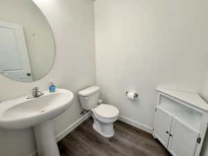 Half bathroom featuring baseboards and dark wood-style floors