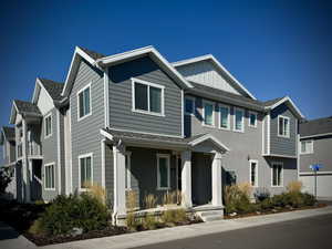 View of front of house with board and batten siding, roof with shingles, and a residential view