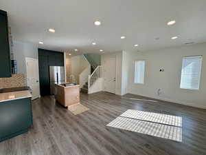 Kitchen featuring an island with sink, recessed lighting, light wood-style floors, open floor plan, and freestanding refrigerator